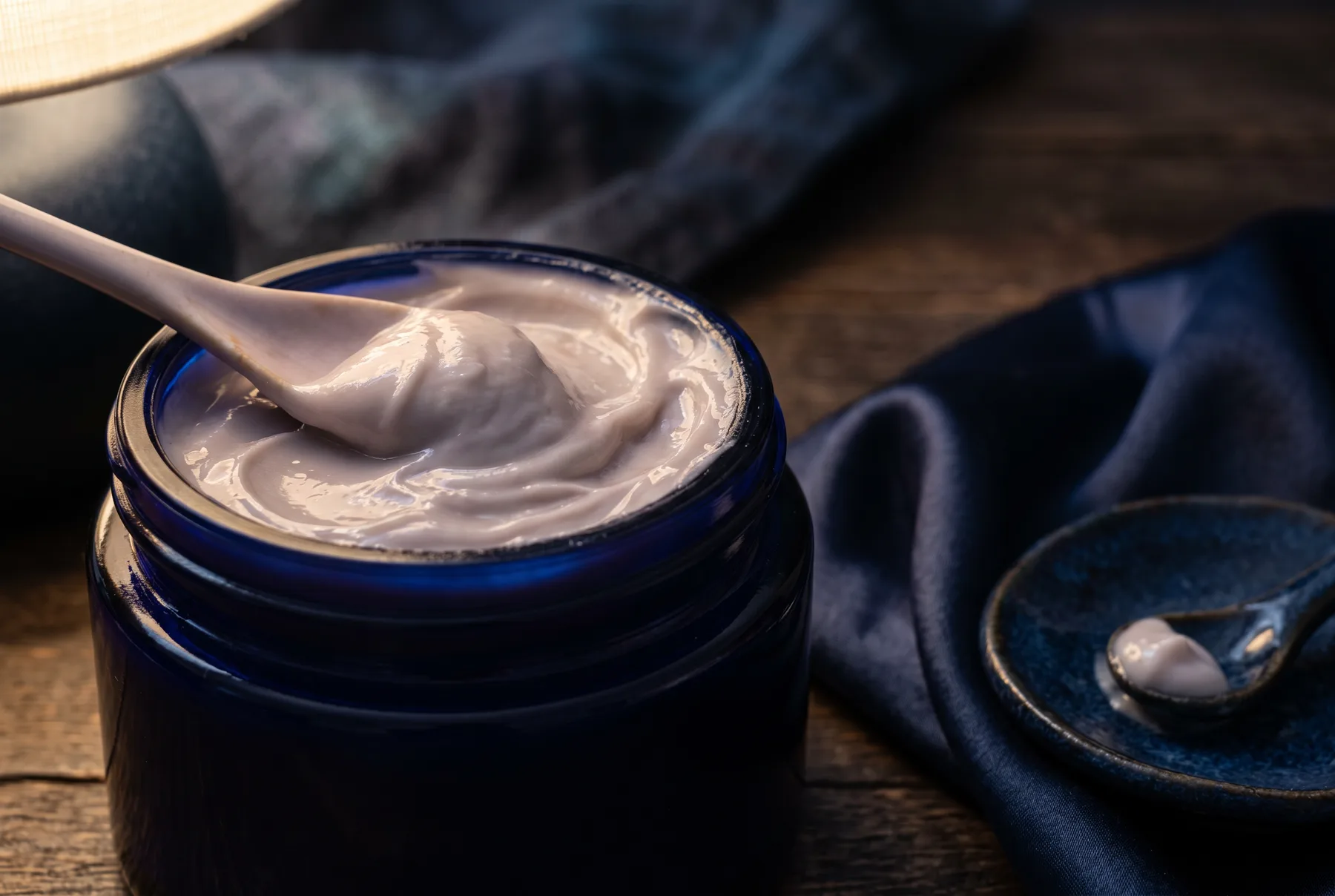 Rich moisturizer texture in a moody nighttime setting