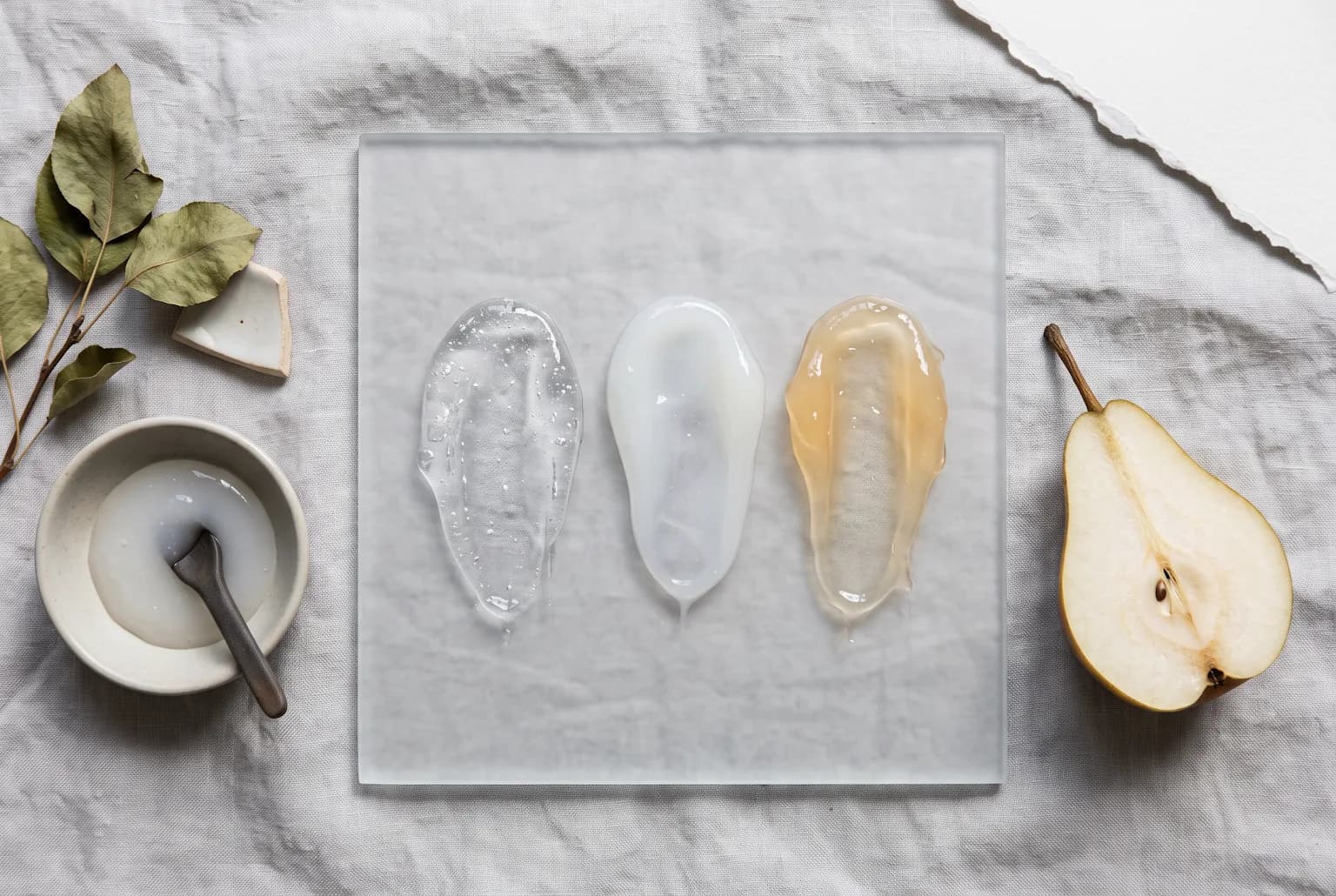 Three translucent skincare textures shown as abstract swatches on frosted glass