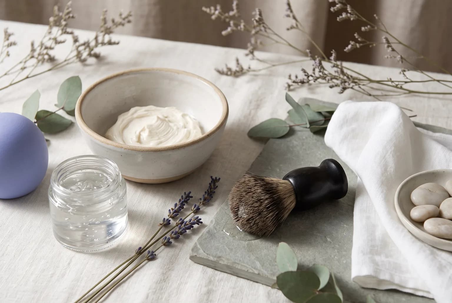 Wet razor and dollop of shaving cream on a ceramic dish