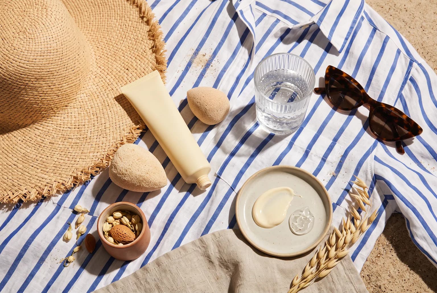 Sun-protection and makeup touch-up accessories arranged on striped fabric